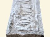 a close up of a stone bench with a flower design on it