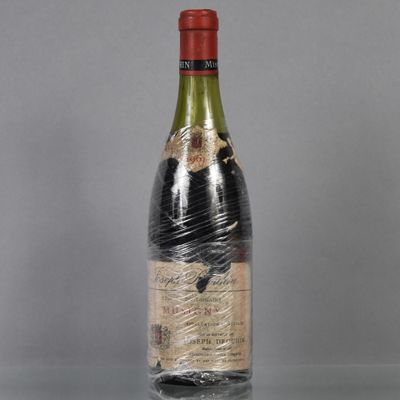une bouteille de vin emballée dans du plastique, posée sur une table