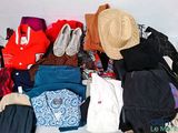 un tas de vêtements et un chapeau posés sur un lit