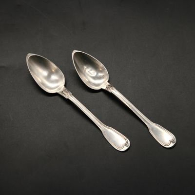 a pair of silver spoons sitting on top of a table