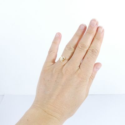 la main d'une femme à laquelle est passée une bague en or