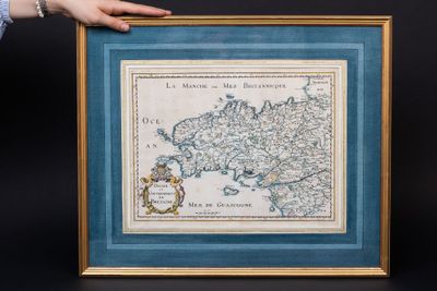 a person holding up a framed map of the country of france