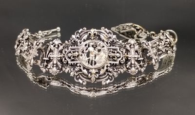 gros plan d'un bracelet en argent sur une surface noire