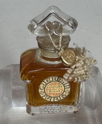 un petit flacon de parfum posé sur une étagère transparente