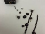 un collier noir, des boucles d'oreilles et une boîte posée sur une table
