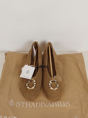 une paire de chaussures marron posée sur un sac marron