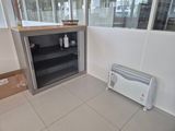 a small refrigerator in the corner of a room next to a heater