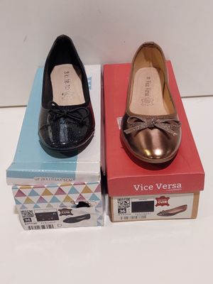 une paire de chaussures pour femme dans leurs boîtes, posées sur une surface blanche