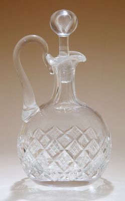 une carafe en verre transparent posée sur une surface blanche