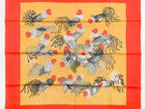 une écharpe orange et jaune ornée de coqs et de fleurs