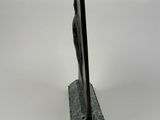 a statue of a man holding a pole on top of a marble base