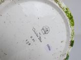 a close up of a green and white vase with a label on it