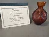a small brown vase next to a card on a table