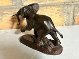 bronze statue of an elephant on a rock with a hat on its head