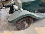 an old green car that is parked in a lot