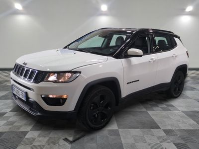 La Jeep Compass blanche est garée sur un sol en carrelage à damier.