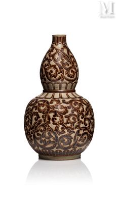 a brown and white vase sitting on a white surface