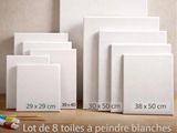 quatre toiles blanches de tailles et de formes différentes, montées sur un support en bois