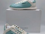 Les chaussures sont bleues et blanches, avec une semelle blanche.
