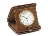 une petite horloge posée sur un coffret marron