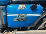 un gros plan d'une moto sur laquelle est accrochée un drapeau à damier
