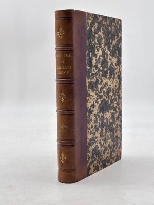 un vieux livre posé sur une table blanche à côté d'un mur blanc
