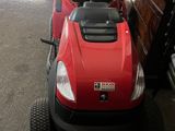 a red lawn mower parked in a garage