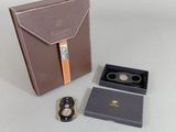 un étui marron contenant une montre et une autre montre à l'intérieur