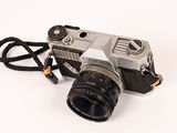 a silver camera with a black strap on a white background