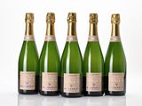 four bottles of champagne are lined up on a white surface