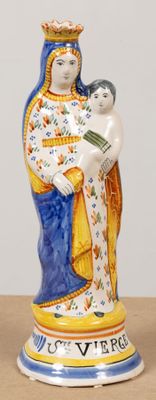 une statue de femme tenant un enfant sur une table