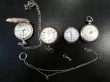 quatre types différents de montres de poche posées sur une table