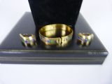 three rings and a ring holder on a black stand