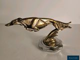 statue of a greyhound running on a base on a table