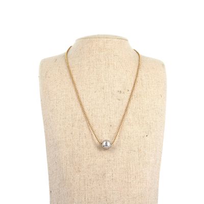 un collier en or orné d'une perle autour du cou d'un mannequin