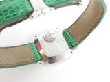 wrist watch with green leather strap and silver buckle on white surface