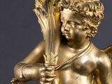 an image of a gold statue of a cupid holding a flower