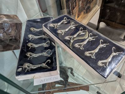 une table en verre sur laquelle est posée une vitrine contenant de l'argenterie