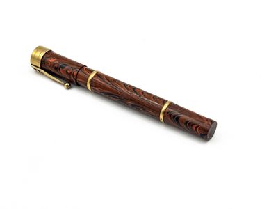 le stylo est en bois et présente des finitions dorées