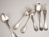 several spoons, forks, and spoons are arranged on a table