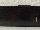 a black purse sitting on a table with a white wall in the background