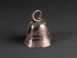 an old silver bell with a snake on it on a black background