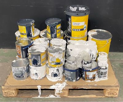many cans of paint sitting on a pallet