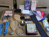 une table sur laquelle se trouvent de nombreux objets, notamment un chapeau, une cravate et d'autres objets