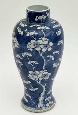 a blue vase with white flowers on it on a white background