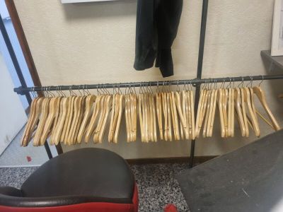 beaucoup de vêtements suspendus à une étagère dans une pièce
