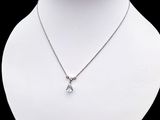 a close up of a necklace on a mannequin with a black background
