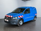 La camionnette bleue est garée dans une pièce blanche ; elle porte une bande rouge et blanche sur le côté.