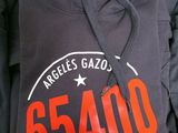 black hoodie with the number 55400 on it in front of a pile of other hoodies