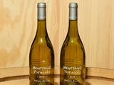 deux bouteilles de vin posées sur un tonneau